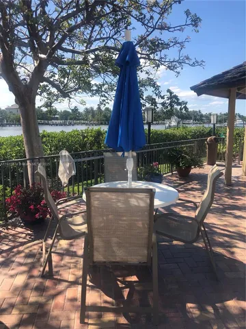 a patio with wooden floor a yard a table and chairs