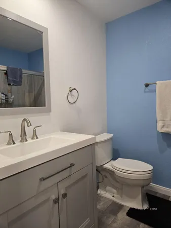 a bathroom with a granite countertop toilet sink and mirror