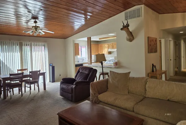 a living room with furniture dining area and a chandelier