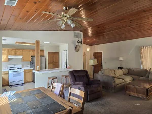 a living room with furniture and a kitchen view