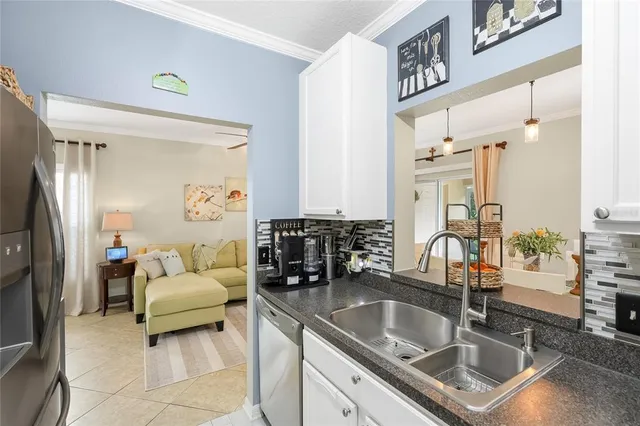 a kitchen with granite countertop a sink cabinets and stainless steel appliances