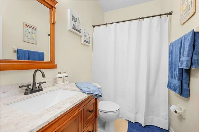 a bathroom with a sink a toilet and shower curtain