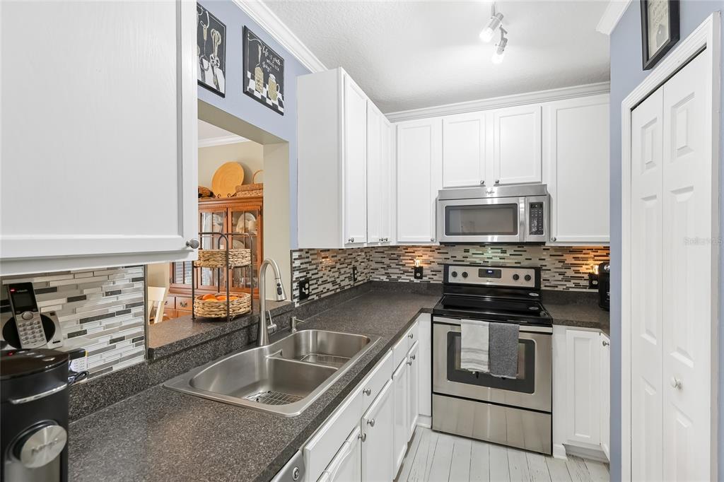 14847 Skip Jack Loop Lakewood Ranch, FL 34202 - Photo 4 of 26 a kitchen with stainless steel appliances granite countertop a stove and a sink