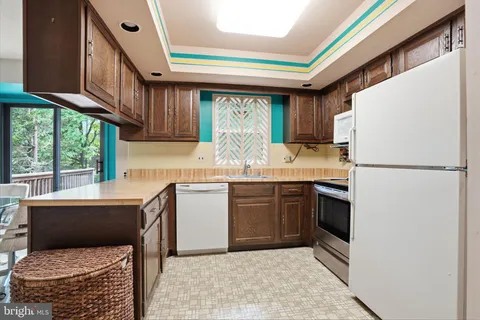 a kitchen with granite countertop a sink appliances a counter space and cabinets