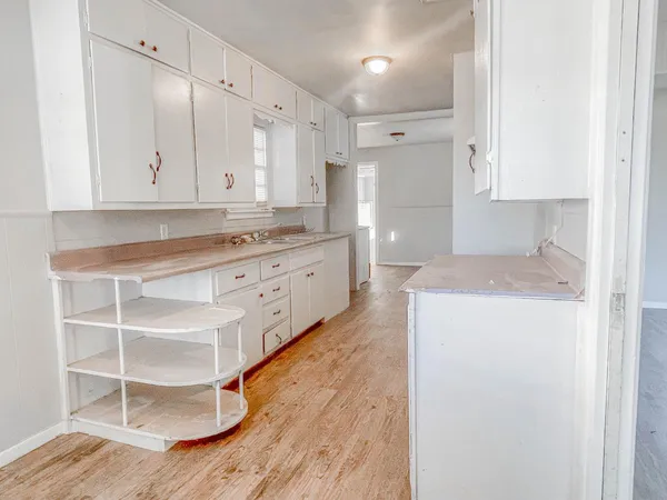 a large kitchen with granite countertop a sink and a stove top oven