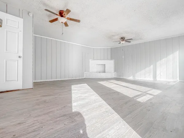 a view of a room with wooden floor and ceiling fan