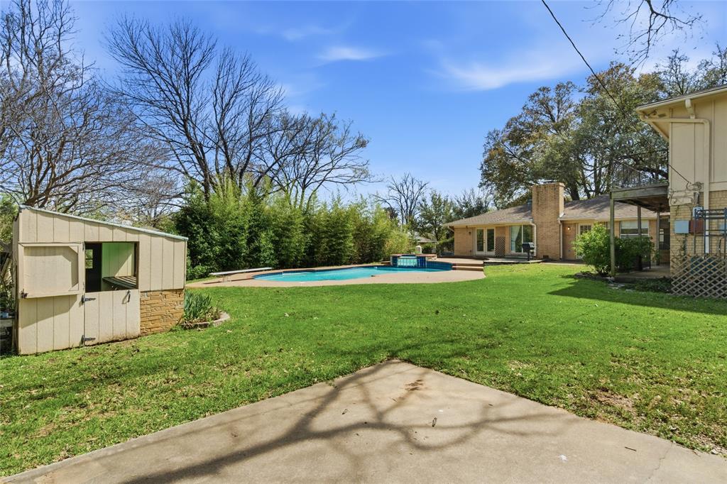 2326 Forest Hills Road Grapevine, TX 76051 - Photo 36 of 37 Backyard with a patio area, an outdoor pool, a storage unit and concrete pad for basketball court
