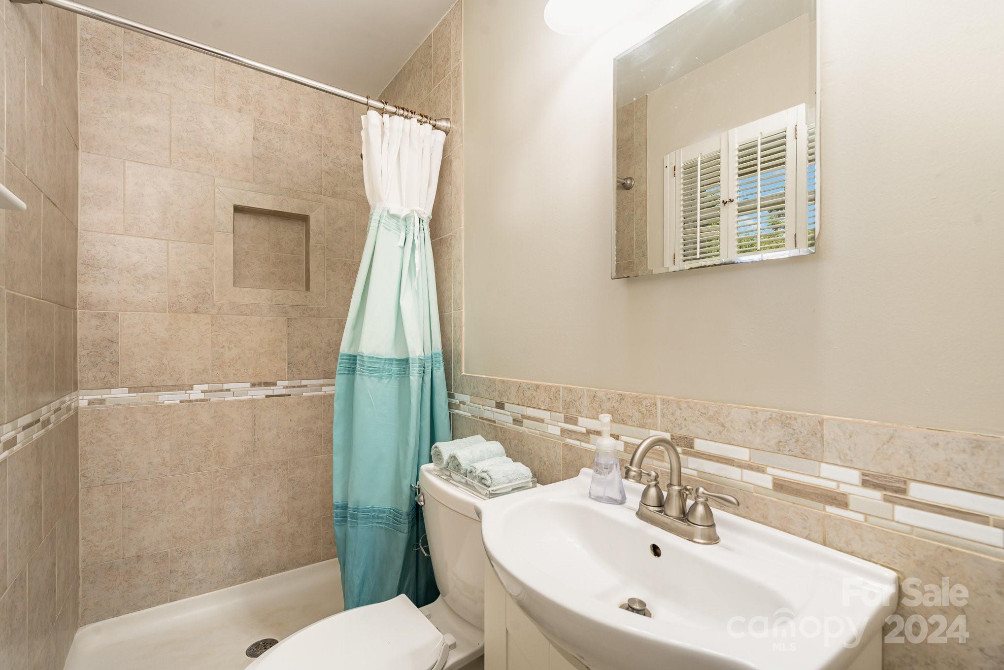 6308 Sunset Circle Charlotte, NC 28216 - Photo 16 of 30 a bathroom with a sink a mirror and a toilet