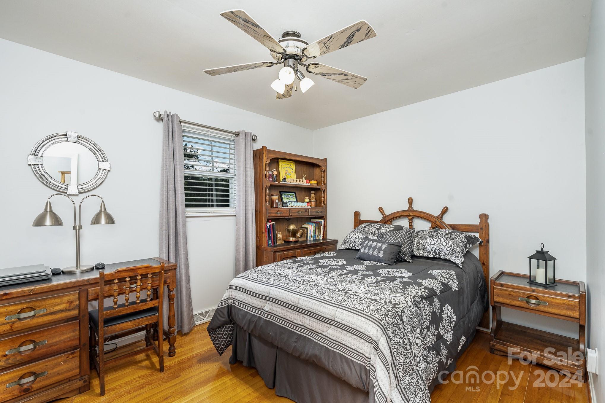 6308 Sunset Circle Charlotte, NC 28216 - Photo 17 of 30 a bedroom with a bed and dresser with wooden floor