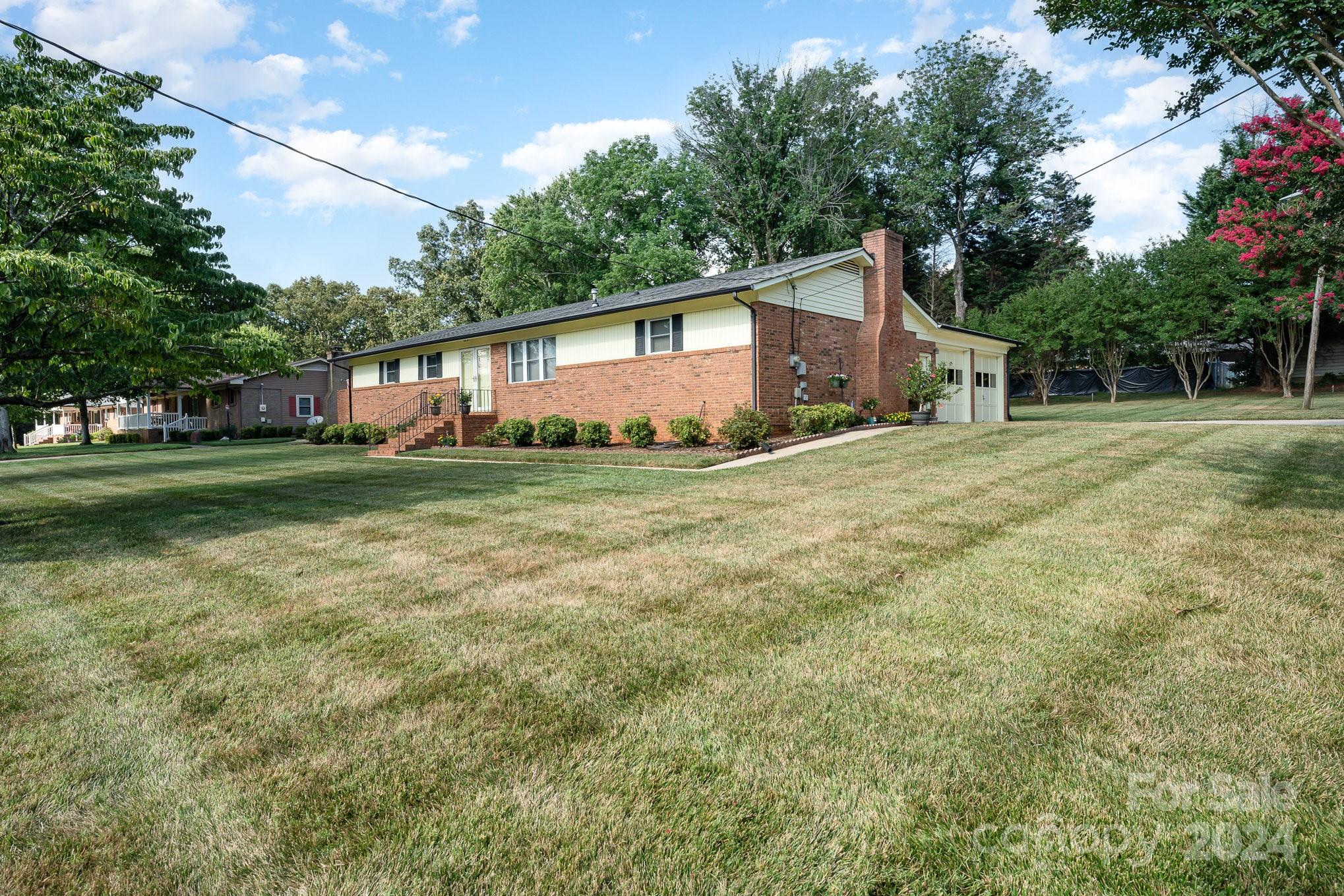 6308 Sunset Circle Charlotte, NC 28216 - Photo 22 of 30 a front view of a house with a yard and trees
