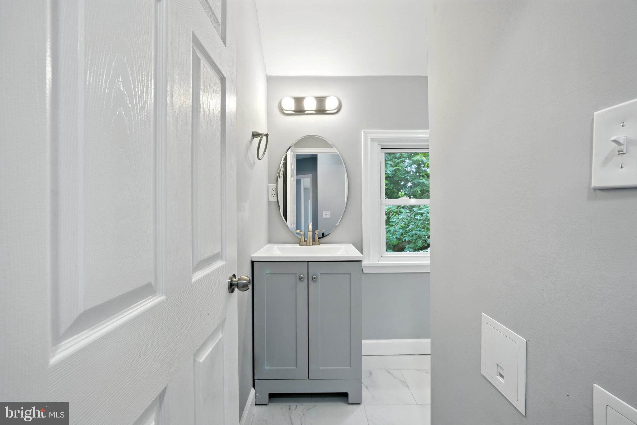 6 New County Road Aberdeen, MD 21001 - Photo 19 of 44 a bathroom with a sink a mirror and a window