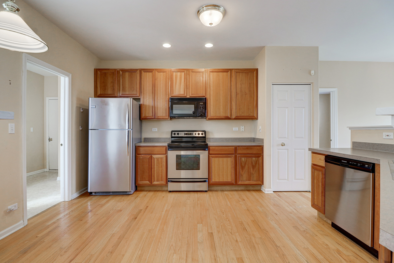 32670 Innetowne Road Lakemoor, IL 60051 - Photo 6 of 25 a kitchen with a refrigerator a stove top oven a sink and dishwasher with wooden floor