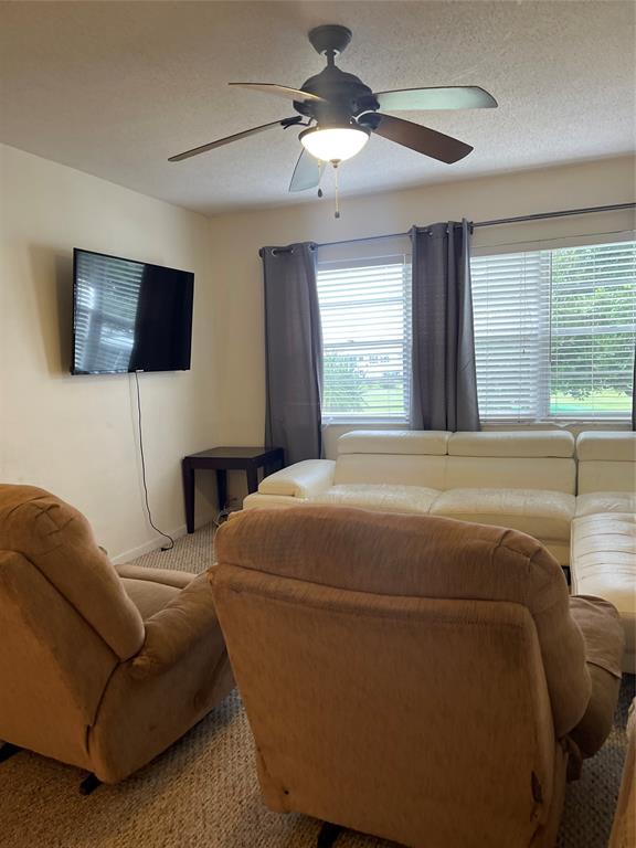 2851 East Golf Boulevard, Unit 206 Pompano Beach, FL 33064 - Photo 20 of 35 a bedroom with a bed a couch and a flat tv