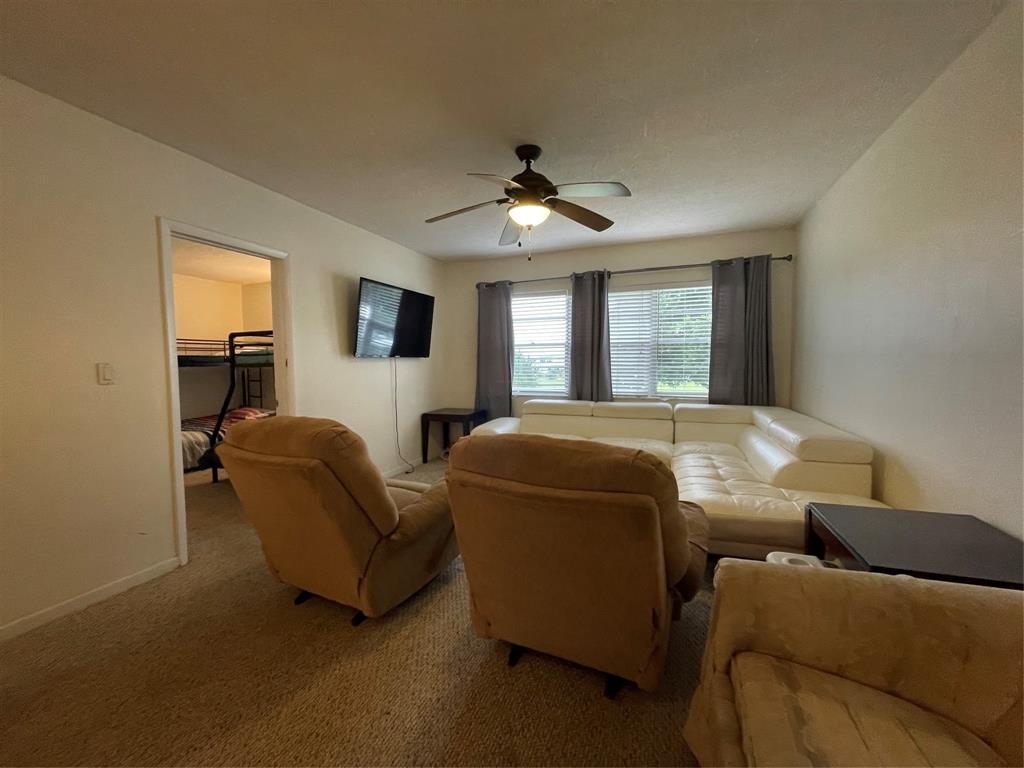 2851 East Golf Boulevard, Unit 206 Pompano Beach, FL 33064 - Photo 21 of 35 a living room with furniture and a chandelier