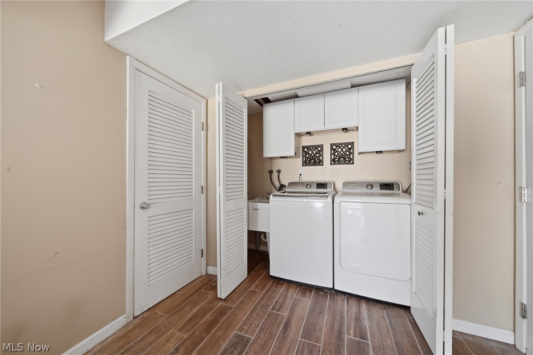 824 South Chillicothe Road, Unit 2 Aurora, OH 44202 - Photo 31 of 42 Dedicated laundry area featuring wood-finish flooring, white louvered bifold doors, and built-in white cabinetry. (lower level)