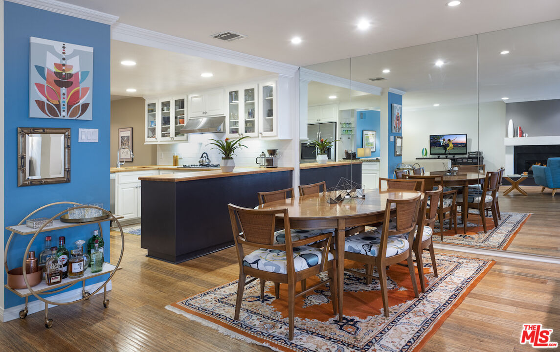 11687 Bellagio Road, Unit 3 Los Angeles, CA 90049 - Photo 11 of 31 a view of a dining room with furniture a rug and wooden floor