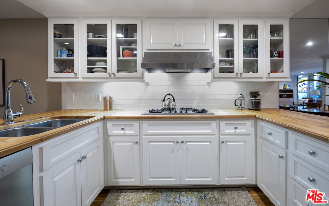 11687 Bellagio Road, Unit 3 Los Angeles, CA 90049 - Photo 13 of 31 a kitchen with white cabinets and sink