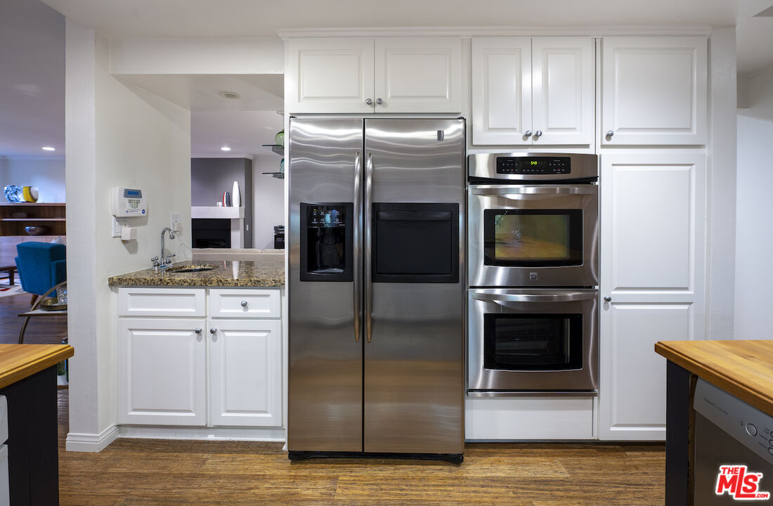 11687 Bellagio Road, Unit 3 Los Angeles, CA 90049 - Photo 14 of 31 a kitchen with stainless steel appliances a refrigerator stove and sink
