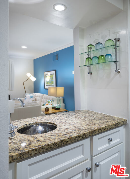 11687 Bellagio Road, Unit 3 Los Angeles, CA 90049 - Photo 15 of 31 a bathroom with a granite countertop sink and a mirror