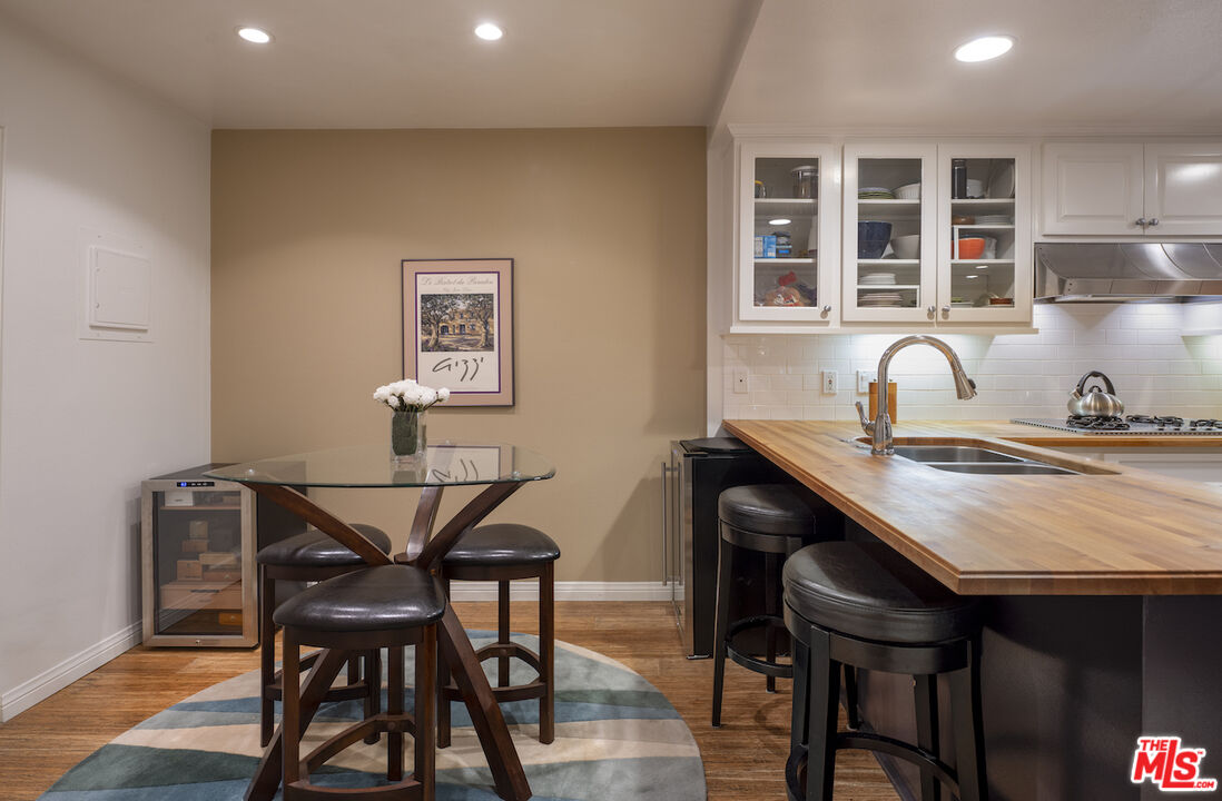 11687 Bellagio Road, Unit 3 Los Angeles, CA 90049 - Photo 17 of 31 a dining room with a wooden table and chairs