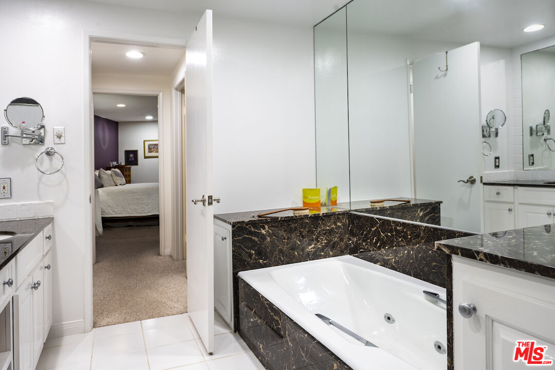 11687 Bellagio Road, Unit 3 Los Angeles, CA 90049 - Photo 21 of 31 a bathroom with a bathtub sink and mirror