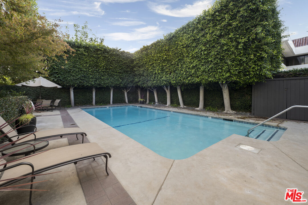 11687 Bellagio Road, Unit 3 Los Angeles, CA 90049 - Photo 26 of 31 a backyard of a house with table and chairs