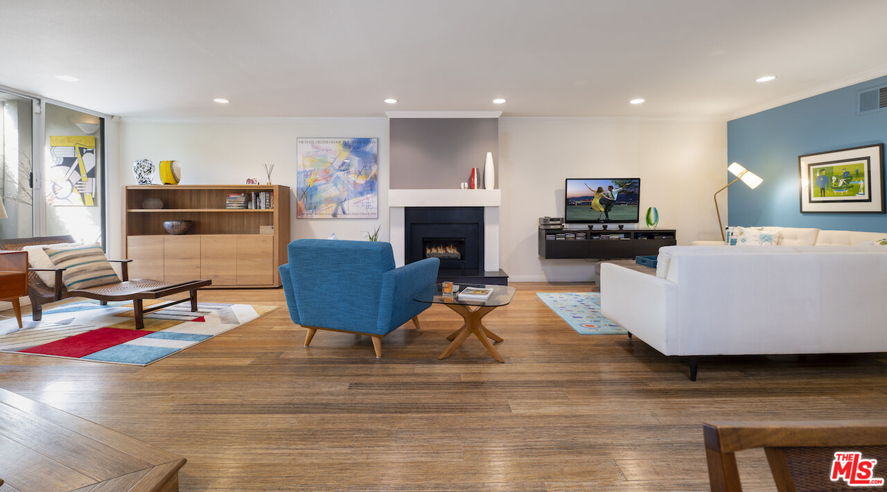 11687 Bellagio Road, Unit 3 Los Angeles, CA 90049 - Photo 7 of 31 a living room with furniture a fireplace and a flat screen tv