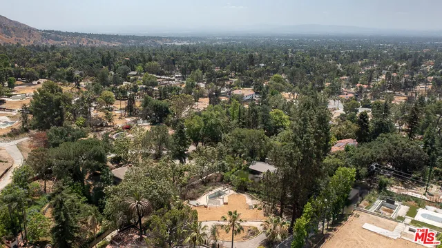 an aerial view of house with yard and mountain view in back