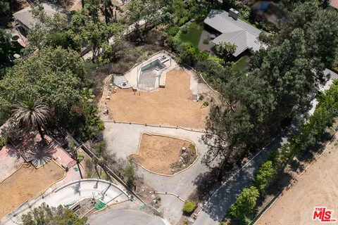 an aerial view of a house with a yard and large trees