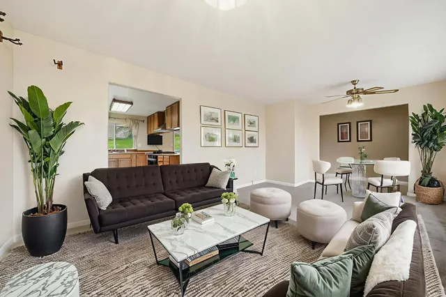 a living room with stainless steel appliances kitchen island hardwood floor and a kitchen view