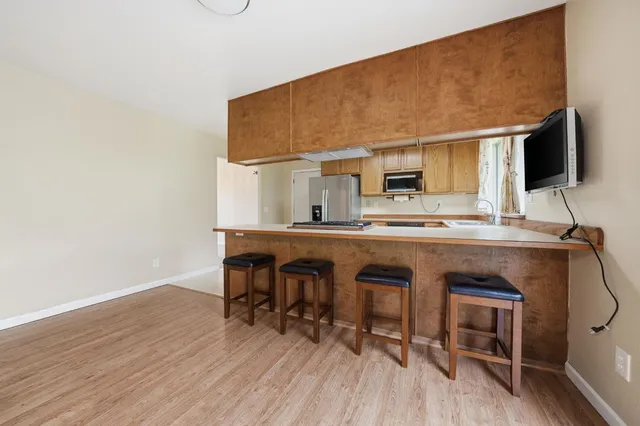 a kitchen with stainless steel appliances a refrigerator sink and white cabinets
