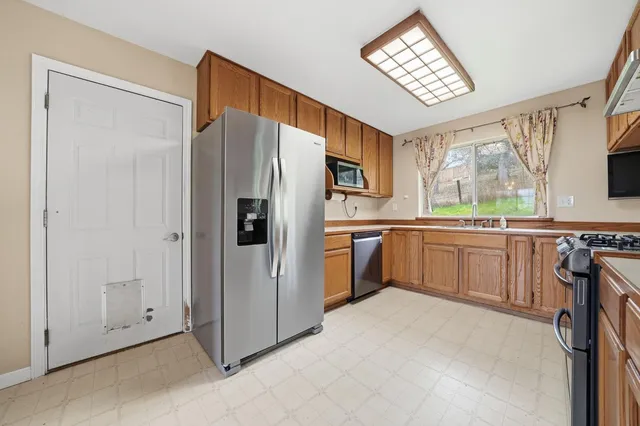 a kitchen with stainless steel appliances granite countertop a refrigerator microwave and sink