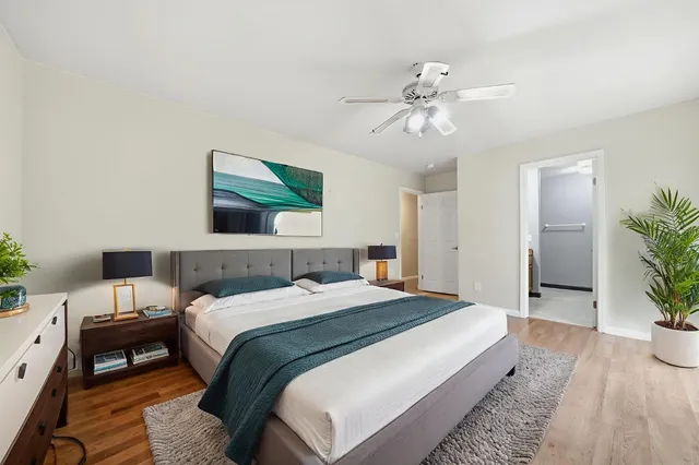 a view of a house with a small yard and a wooden deck