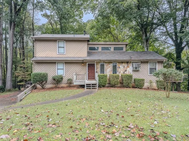 a view of a house with backyard and chairs