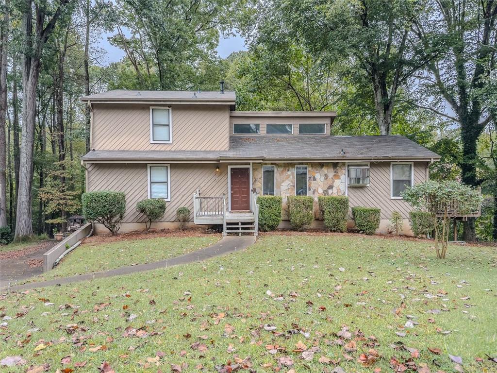 a view of a house with backyard and chairs