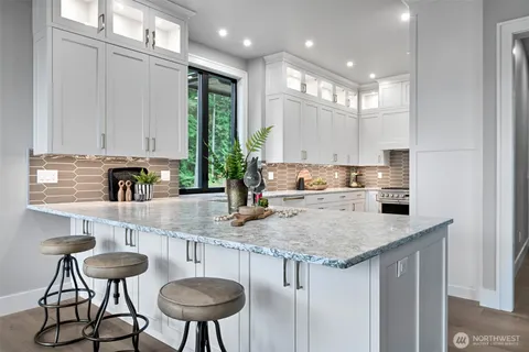 a kitchen with stainless steel appliances granite countertop a sink and a refrigerator