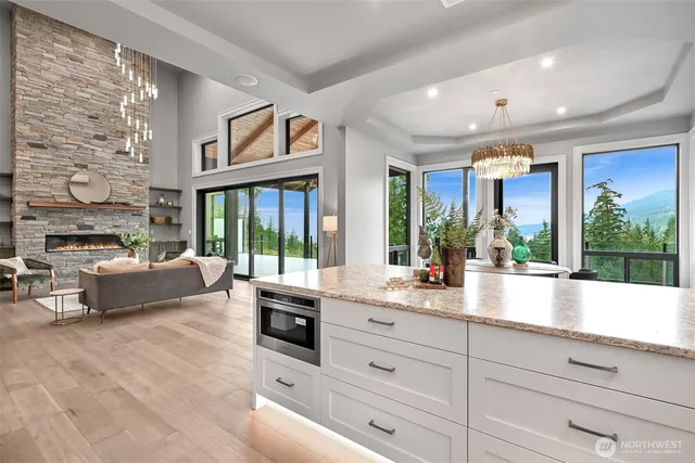 a large living room with large windows and large tree