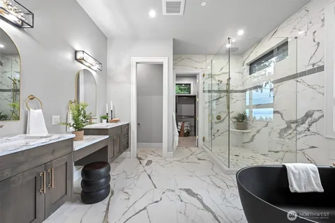 a spacious bathroom with a granite countertop sink a mirror and shower
