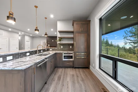 a kitchen with stainless steel appliances granite countertop a stove a sink and a refrigerator