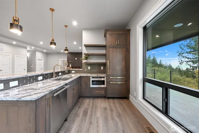 a kitchen with stainless steel appliances granite countertop a stove a sink and a refrigerator