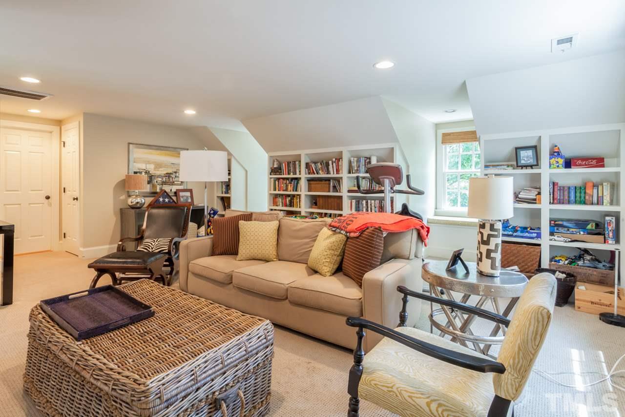 2425 Coley Forest Place Raleigh, NC 27612 - Photo 19 of 24 a living room with furniture a rug and a book shelf