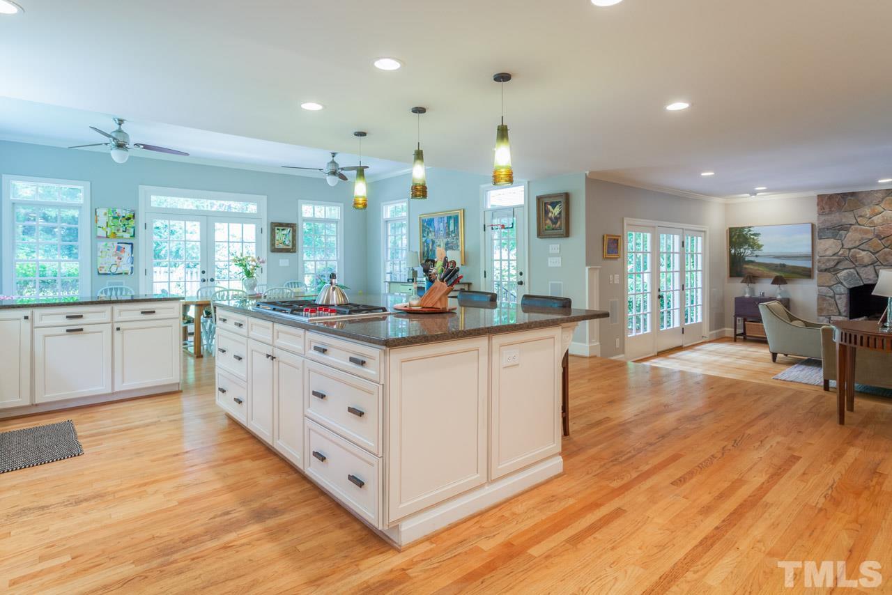 2425 Coley Forest Place Raleigh, NC 27612 - Photo 4 of 24 a large kitchen with kitchen island a large counter space a sink stainless steel appliances and cabinets