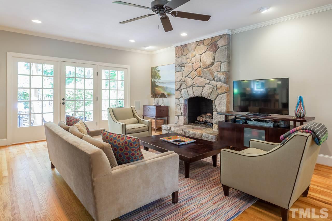 2425 Coley Forest Place Raleigh, NC 27612 - Photo 7 of 24 a living room with furniture a fireplace and a flat screen tv