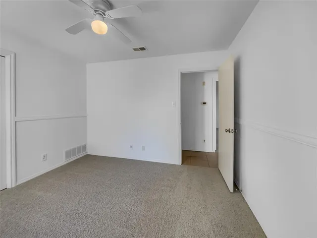 an empty room with a empty space and a ceiling fan