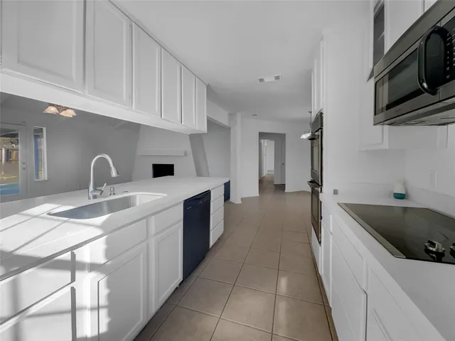 a kitchen with granite countertop a sink and a stove top oven
