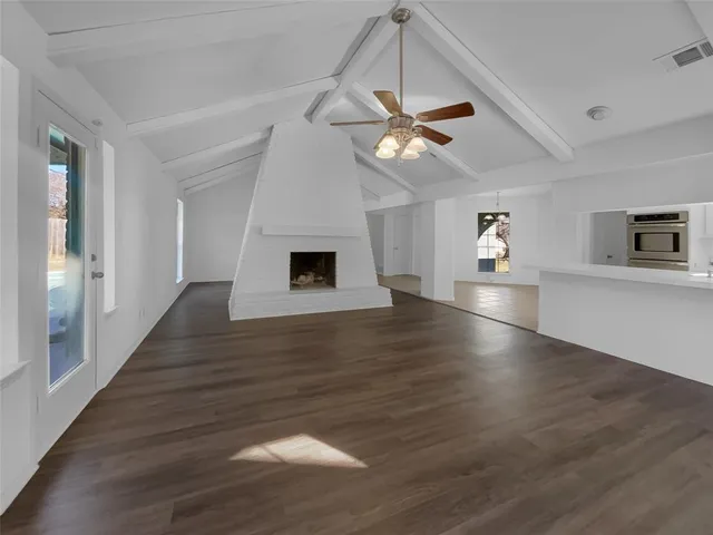 a view of empty room with wooden floor and ceiling fan