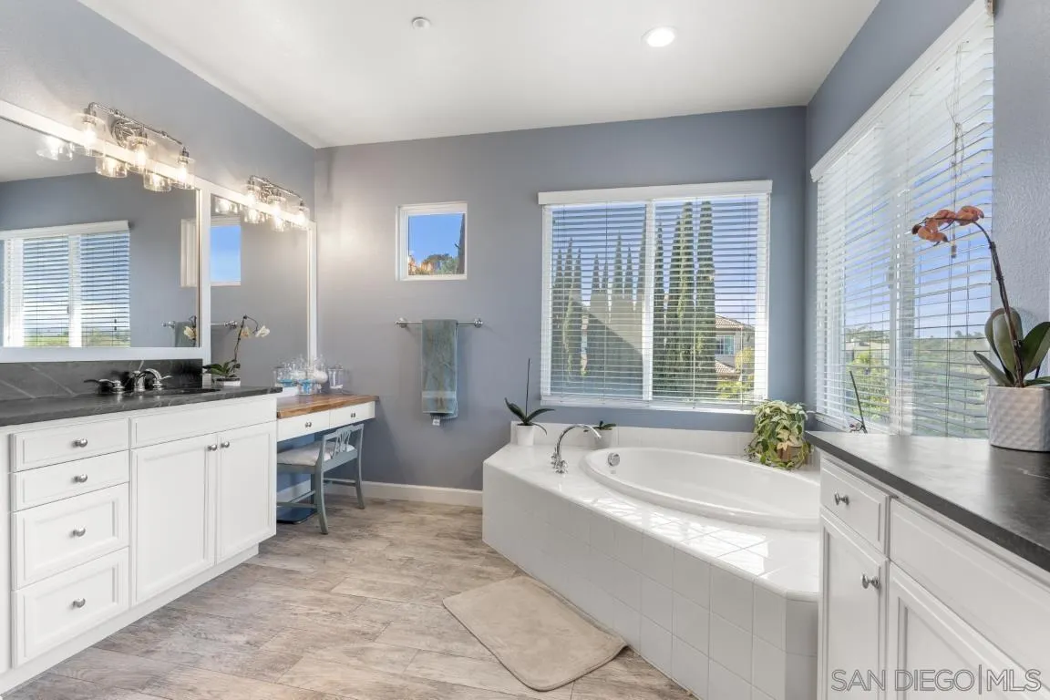 310 Highland Oaks Court Fallbrook, CA 92028 - Photo 31 of 52 a spacious bathroom with a double vanity sink a large mirror and a bathtub