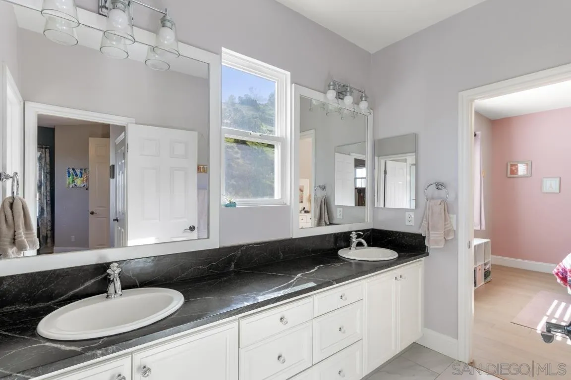 310 Highland Oaks Court Fallbrook, CA 92028 - Photo 32 of 52 a bathroom with a sink and a mirror