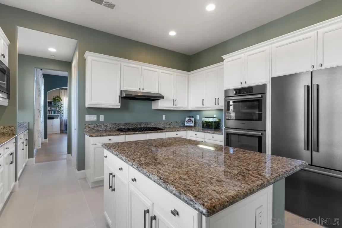 310 Highland Oaks Court Fallbrook, CA 92028 - Photo 8 of 52 a kitchen with stainless steel appliances granite countertop a sink stove and refrigerator