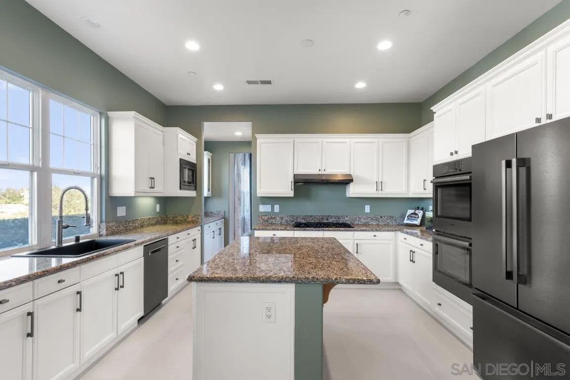 310 Highland Oaks Court Fallbrook, CA 92028 - Photo 9 of 52 a kitchen with granite countertop a sink stainless steel appliances and cabinets
